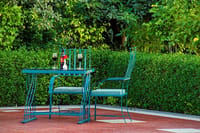 A table for two by the hedge beside the pool