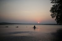 Children swimming in the Kabini river at sunset