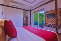 A bed at Ananyamaya looking out through the balcony to the trees