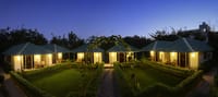 The garden cottages lit at dusk