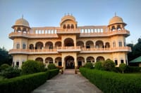 The front of Ranthambhore Heritage Haveli by day, garden tables on the lawn