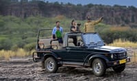 An open Gypsy on a track below the Ranthambhore cliffs