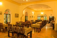 The multi-cuisine restaurant, stained-glass windows and wooden tables