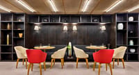 Jigsaw dining room with dark shelves, lamps and red armchairs