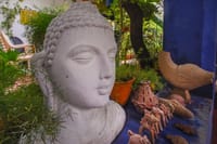 Stone Buddha head and terracotta figures in the garden