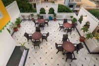 Crenellated second-floor terrace with round tables and planters