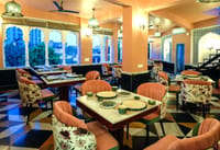 The rooftop restaurant at Dev Mahal at dusk, arches open to the Jaipur skyline