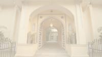 Arched gateway view into the haveli (site hero image, pale overlay baked in)
