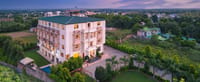 Wide aerial hero of the resort amid greenery (panoramic crop)
