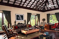 Lounge with vaulted timber ceiling, chandelier, sofas and writing desk at Samode Safari Lodge, Bandhavgarh