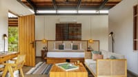 Luxury Room — bedroom with king bed, cane sofa, teak furniture and clerestory windows at Bori Safari Lodge, Satpura