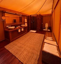 Tented Suite — bathroom with twin basin vanity, jute rug and bamboo-screened shower at Bagh Villas, Kanha