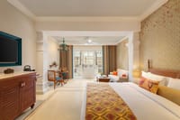 Deluxe Room King Bed Courtyard View with king bed, sofa seating and balcony doors to the courtyard at Pilibhit House, Haridwar