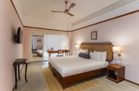 Angirasa bedroom with cane headboard, writing desk and sliding door to the connecting room at Amrit Bhawan, Haridwar