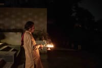 Priest holding an oil lamp during evening aarti at the ghat at Amrit Bhawan, Haridwar