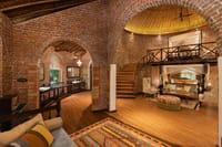 Brick Villa with King Beds interior with brick arches, domed ceiling, spiral stair and mezzanine bed at Jaagir Manor, Dudhwa