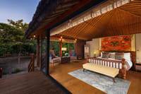 SeleQtions Villa with King Bed under a bamboo-lined roof with deck overlooking the mango orchard at dusk at Jaagir Manor, Dudhwa
