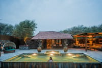 The Blackbuck Suite private pool lit at dusk with day-bed and covered lounge at The Blackbuck Lodge, Velavadar