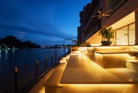 Stepped private ghat terraces lit at dusk beside the Ganga at Ekaanta, Haridwar