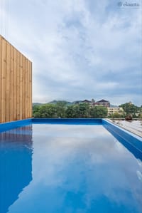 Rooftop plunge pool with timber screen and views towards wooded hills at Ekaanta, Haridwar