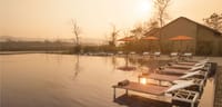 Poolside at Meghauli Serai with view over the Rapti River and jungle