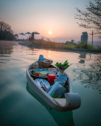 Breakfast served in a floating wooden boat on the pool at sunrise at Barahi Jungle Lodge, Chitwan