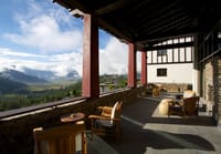 Covered terrace with armchairs overlooking the Phobjikha valley at Gangtey Lodge, Gangtey