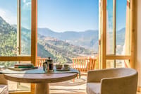 Coffee tray on a table beside open doors to a private terrace with valley views at Bhutan Spirit Sanctuary, Paro