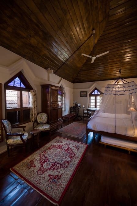 Deluxe Room with twin beds on the second floor of The Old Courtyard Hotel, high timber ceiling and arched window