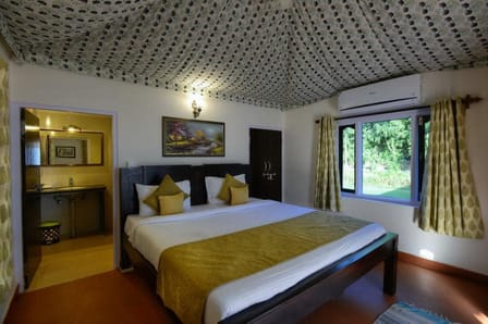A cottage room with a tented ceiling and garden window