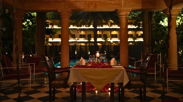 Red-sandstone palace facade lit at night, seen across the pool from the baradari, Ranbanka Palace, Jodhpur