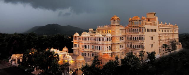Chunda Palace exterior lit at dusk against the Aravali hills