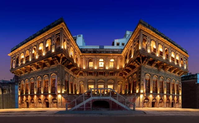 WelcomHeritage Badi Kothi lit up at night, carved sandstone facade