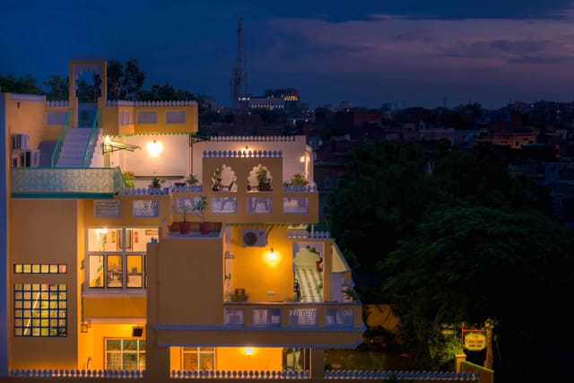 Coral Court exterior at dusk, lit house against evening sky