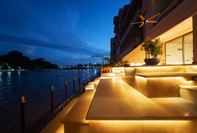 Stepped private ghat terraces lit at dusk beside the Ganga at Ekaanta, Haridwar