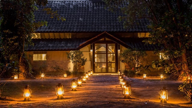 Lantern-lit path leading to the lodge entrance at dusk at Tiger Tops Tharu Lodge, Chitwan