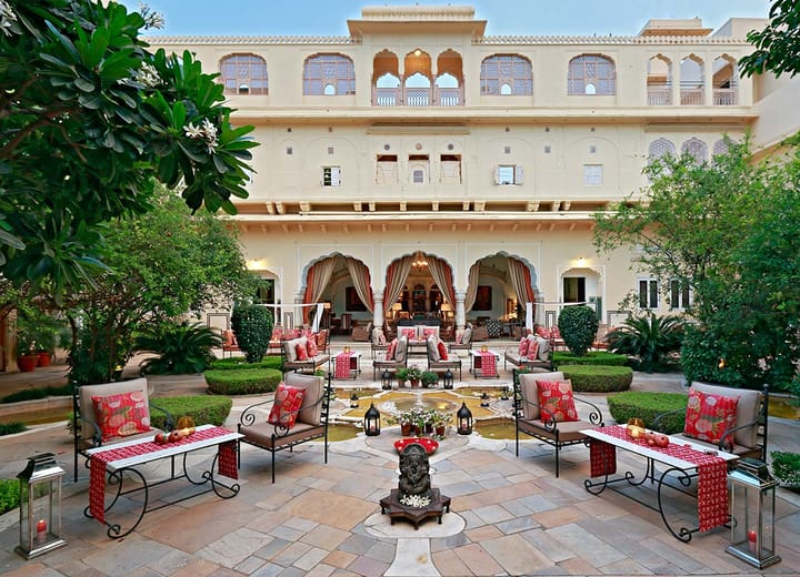 Evening dining tables set in the main courtyard beneath the haveli's arched facade