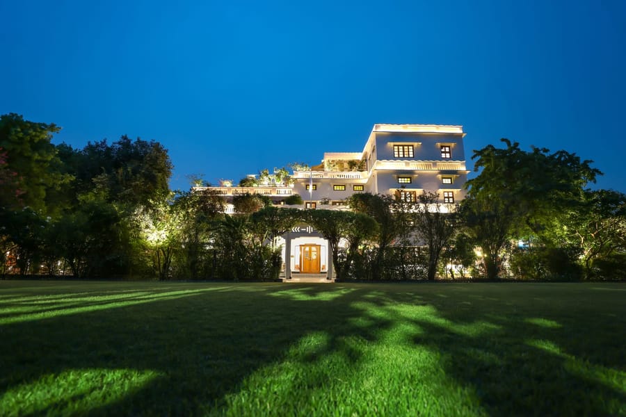 Front lawn and lit Art Deco facade at dusk, Saraca Hotel Lucknow, Lucknow
