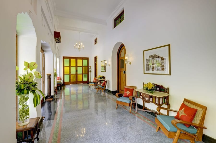 Lobby corridor with terrazzo floor, coloured-glass doors and cane armchairs, Saraca Hotel Lucknow, Lucknow