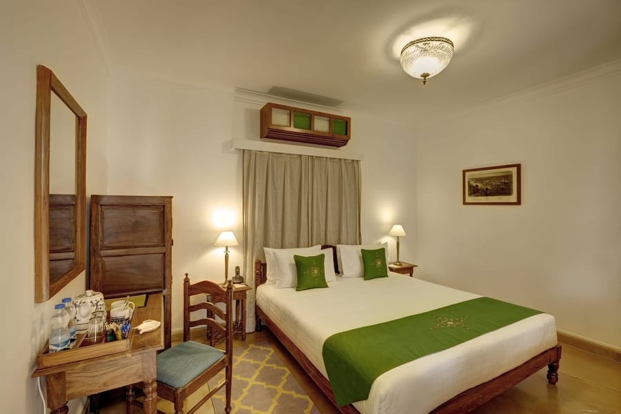 Residency Room with a double bed, writing desk and coloured-glass window panel, Saraca Hotel Lucknow, Lucknow
