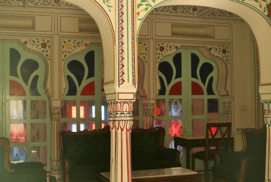 The corridor at Kothi Pushkar, with its painted arches and plants