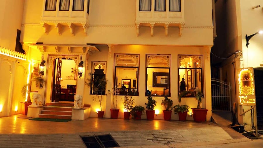 Haveli facade with jharokha balconies lit at night