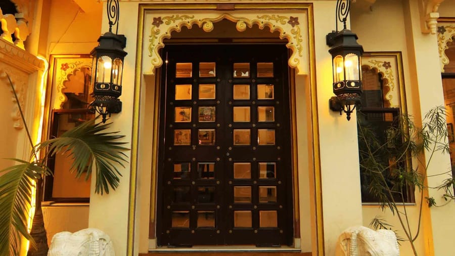 Massive carved wooden door flanked by lanterns
