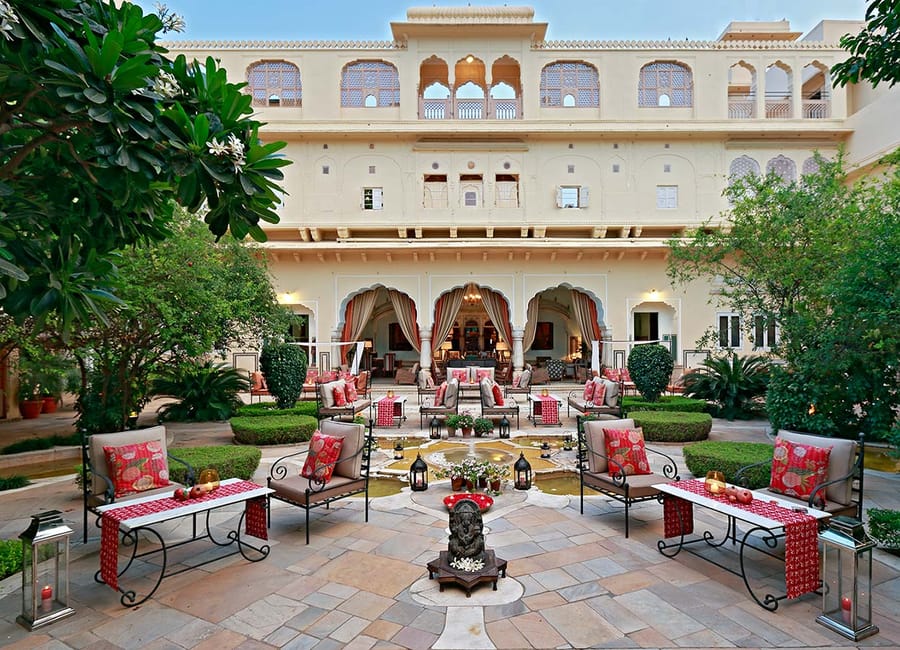 Evening dining tables set in the main courtyard beneath the haveli's arched facade