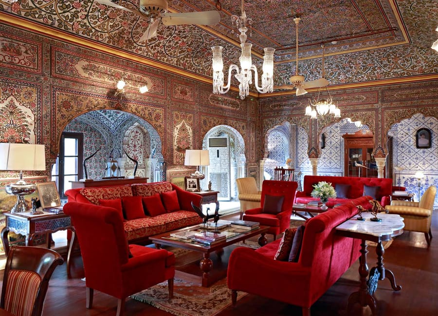 Frescoed lounge with red velvet sofas and chandelier