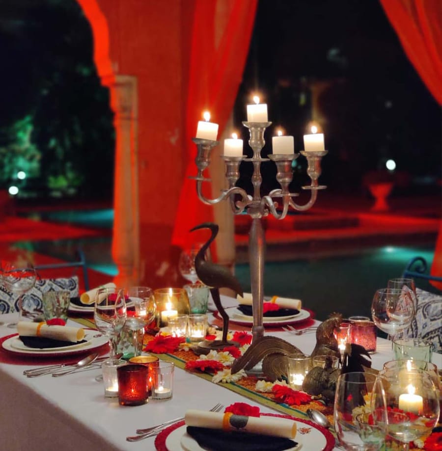 Candlelit private dining table with candelabra beside the pool