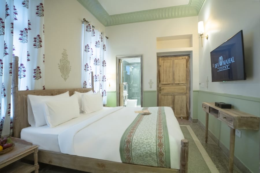 Four-poster bed and green trim in a room at Dev Mahal, Jaipur