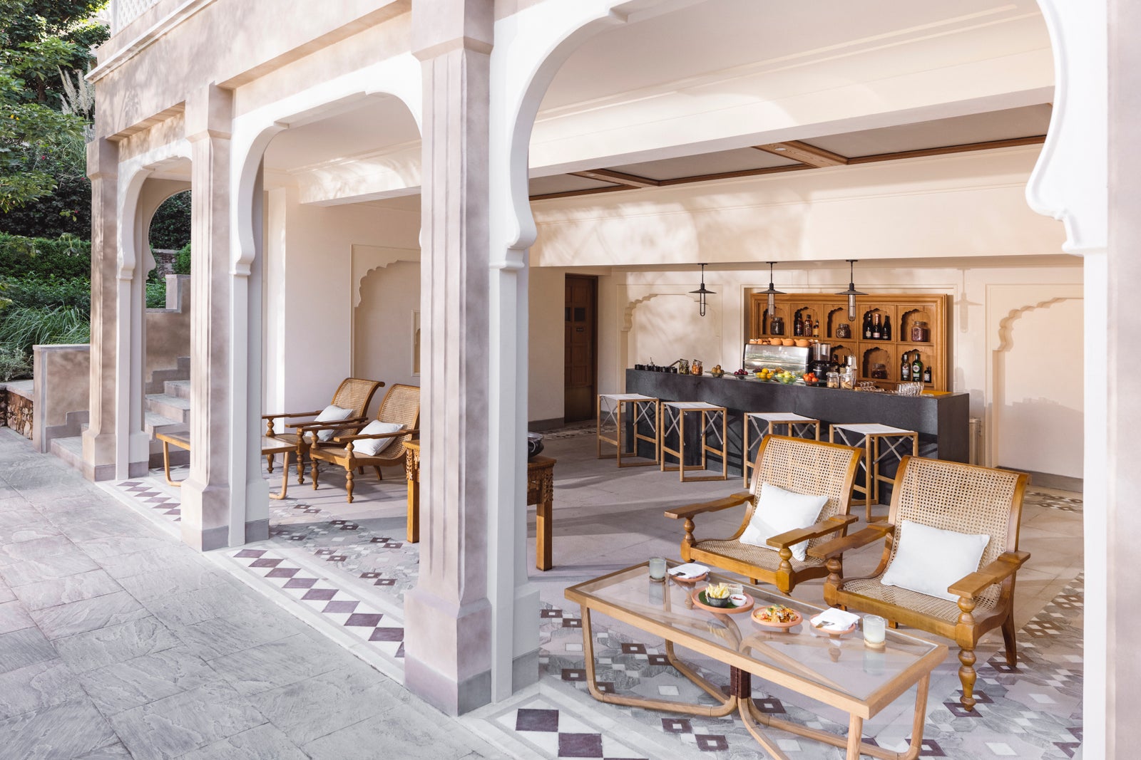 Rani Bagh, the poolside dining venue: arched veranda, cane planter chairs, bar counter. No people.