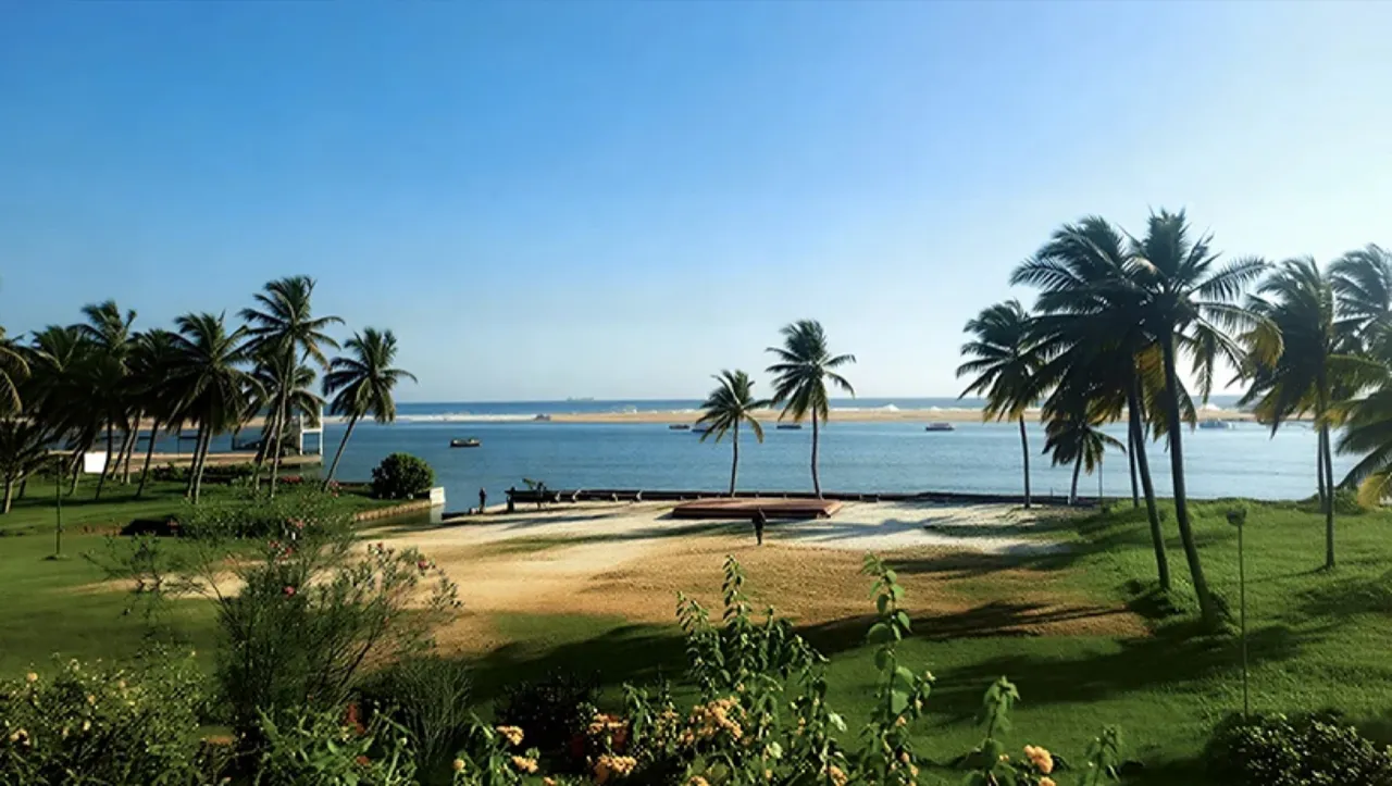 Coconut palms and lawns at Isola di Cocco where the Poovar backwater meets the sea, Kerala